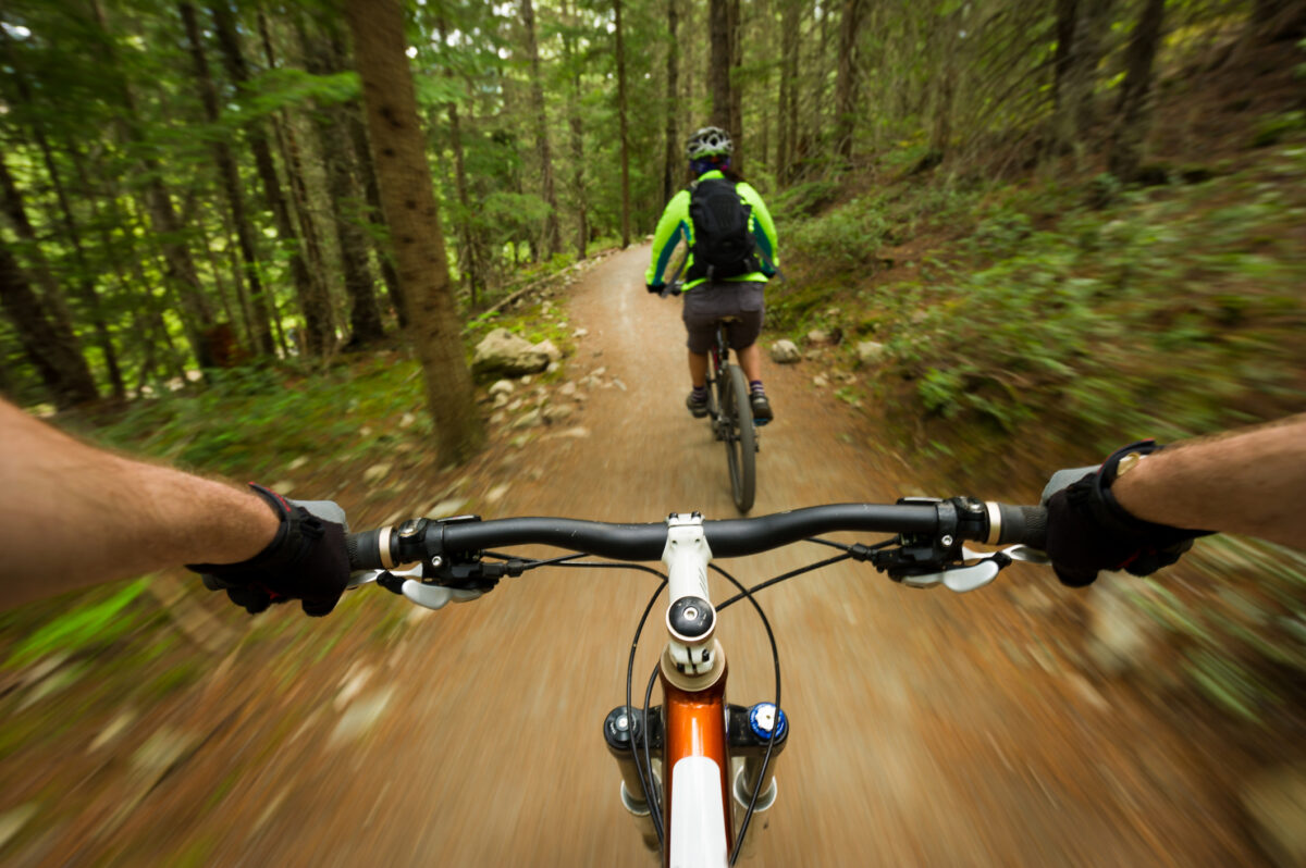 POV image of a mountain biker following another biker on a trail